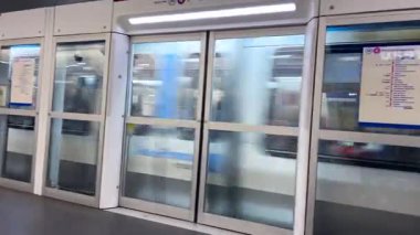 Modern metro istasyonu Denfert-Rochereau 'ya tren geliyor. Otomatik kapıları olan saydam bariyerlerle dolu. Aynı anda Paris, Fransa tren kapıları açılıyor..