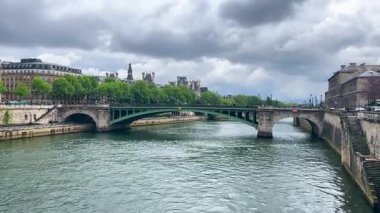 Paris ve Pont Notre Dame köprüsünün Paris, Fransa 'da bulutlu bir bahar gününde Seine nehri üzerindeki panoramik manzarası.