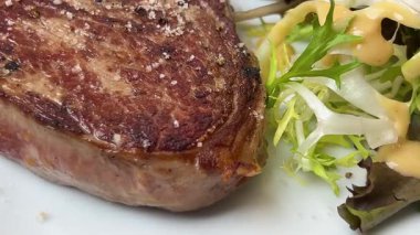 Fransız mutfak restoranlarından birinde lezzetli bir kabuklu, salatalı ve et soslu sulu pirzola bifteği, Paris, Fransa.