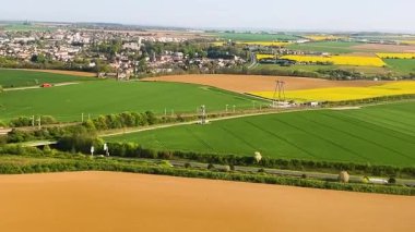 Paris, Fransa 'ya inen bir uçak. Resimli tarlaların lombozundan manzara, ilkbahar güneşinin ışınlarındaki köyler....