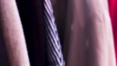 Pembe, mavi, mor ve fuşya renginde gömlek ve bluzlar Fransa 'nın Marais bölgesindeki bir mağazadaki elbise askılarında asılı..