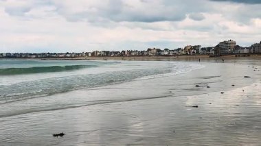 Saint-Malo, Brittany, Fransa 'nın İntra-Muros bölgesine tepeden bakan İngiliz Kanalı' nda su seviyesi düşük ıslak kum ve küçük dalgaların ayna benzeri yüzeyi..