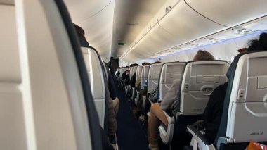 Uçuş sırasında yolcularla dolu bir uçak kabini..