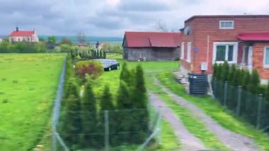 Resimli Polonya köylerinin, kır evlerinin ve avluların otobüs penceresinden manzara.