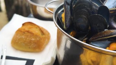 Bir kız, Saint-Malo 'da Manş Denizi' ne bakan bir kafede elleriyle kabuklu midye yiyor..