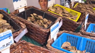 PARIS, FRANCE - 21 Nisan 2025: Değişik türde ve boyutlarda taze istiridye sepetleri, Paskalya 'dan önce Montparnasse bölgesindeki bir çiftçi pazarında sıralanmış saksı çiçekleri.