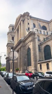 PARIS, FRANCE - 21 Nisan 2025: 6. Bölge 'de sokaklarda yürüyüş. Saint-Sulpice Kilisesi manzarası. Dikey video.