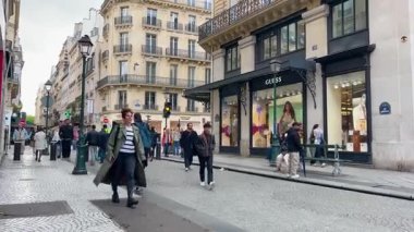 PARIS, FRANCE - 21 Nisan 2025: Seine Nehri 'nin sağ kıyısındaki Marais bölgesinde restoranları ve dükkanları olan kalabalık bir Paris yaya sokağı manzarası.