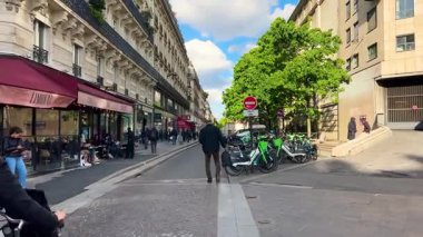 PARIS, FRANCE - 21 Nisan 2025: Seine Nehri 'nin sağ kıyısındaki Marais bölgesinde restoranları ve dükkanları olan kalabalık bir Paris yaya sokağı manzarası.
