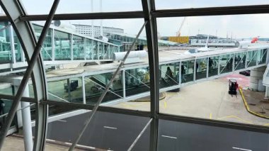 PARIS, FRANCE - 28 Nisan 2025: Paris 'e gelen yolcuların çıkış salonunun pencerelerinden uçaktan inerken ve Charles de Gaulle Havaalanı' ndan çıkmak için camdan bir tünelden geçerken.