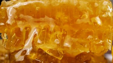 Altın bal, bal peteklerinden akıyor. Balmumu bal peteklerine yakın çekim. Makro atış. Sağlıklı yeme kavramı.