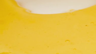 Altın bal damlaları beyaz bir tabağa damlar ve bal birikintisi oluşturur. Sağlıklı yeme kavramı.