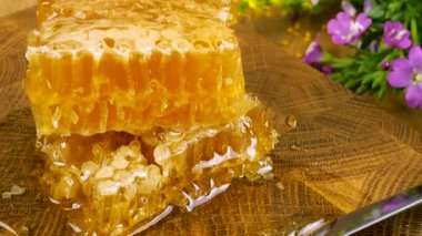 Tahta bir meşe ağacını baldan tahıl kesme tahtasını bıçakla kepçeleyip bal peteğine aktararak temizlemek. Balmumu hücrelerini arı balı ile kapatın. Sağlıklı yeme kavramı.