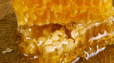 Tahta bir meşe ağacını baldan tahıl kesme tahtasını bıçakla kepçeleyip bal peteğine aktararak temizlemek. Balmumu hücrelerini arı balı ile kapatın. Sağlıklı yeme kavramı.