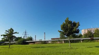 Aktarım hatları, üstten elektrik hatları veya yüksek voltajlı elektrik hatları ve mavi gökyüzüne karşı boru hattı.