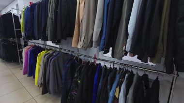 Mağazadaki askılarda bir sıra erkek giysisi..