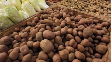 Kırmızı soğan, pancar, patates, havuç ve Napa lahana bir alışveriş merkezinde ahşap kasalarda..
