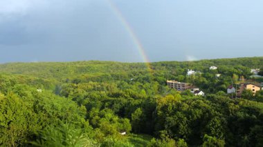 Orman ve bulutların arka planında gökkuşağı.