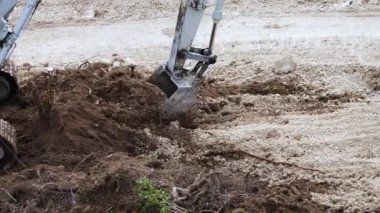 Bir kazıcı, bir inşaat alanında kazı çalışması yapıyor.