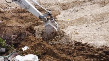 Bir kazıcı, bir inşaat alanında kazı çalışması yapıyor.