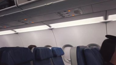 TORONTO, CANADA - 3 AĞUSTOS 2025: Yolcular, tepe kapakları ve Kanada 'nın Montreal kentinden kalkmayı bekleyen bir uçağın kabini.