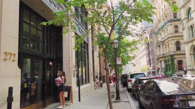 MONTREAL, CANADA - 10 Ağustos 2025: Güzel bir kız Montreal, Quebec, Kanada 'da Saint-Jacques Caddesi 272 numaradan binaya girer. Şehrin tarihi mimarisi..