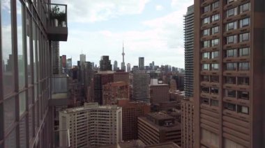 TORONTO, CANADA - SEPTEMBER 5, 2025: Toronto şehir merkezi, CN Kulesi üzerindeki bir gökdelenin yüksek katından panoramik manzara ve bir yaz akşamı gökyüzünü ve bulutları yansıtan güzel tek bir gökdelen. Toronto, Ontario, Kanada.