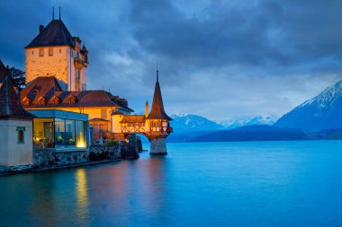 Panoramic view of Oberhofen Castle during twilight, Lake Thunersee, Bernese Highlands, swiss Alps, Switzerland clipart