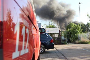 Berlin, Almanya - 20 Mayıs 2025: Berlin 'in Spandau bölgesindeki bir yangından yükselen yoğun gri duman. Duman bulutları aktif bir acil durum sinyali veriyor, uzaktan görülebilir. .