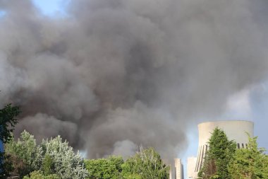 Berlin 'in Spandau bölgesindeki bir yangından yükselen kalın gri duman. Duman bulutları aktif bir acil durum sinyali veriyor, uzaktan görülebilir. .