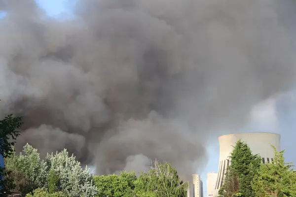 Berlin 'in Spandau bölgesindeki bir yangından yükselen kalın gri duman. Duman bulutları aktif bir acil durum sinyali veriyor, uzaktan görülebilir. .