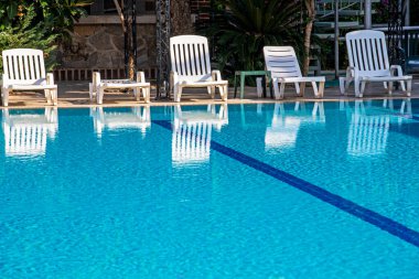 Havuz kenarındaki boş güneş pansiyonları, turist tatili.