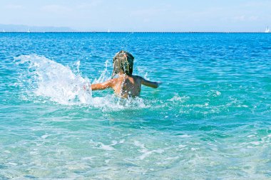 Arkadan gelen kız denize sıçrıyor