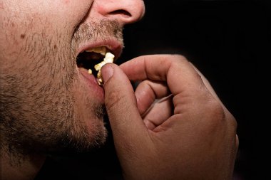 Patlamış mısır yiyen bir adamın profili