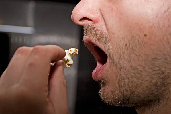 profile of a man eating popcorn