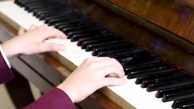 Genç piyanist bir konserde iki eliyle klasik bir parça çalar. müzik