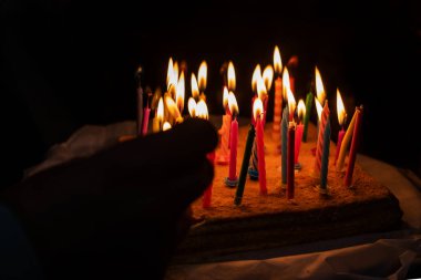 Doğum günü pastasının üzerinde yanan mumlar.