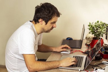 Programcı evdeki bilgisayarda bir çiçekle kodlama yapıyor..