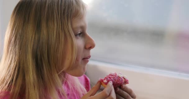 Happy Little Blonde Girl Pink Eats Pink Donut Icing Window — Video Stock
