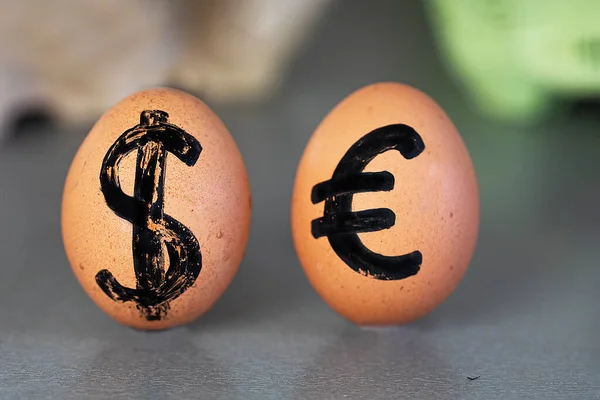 simple eggs with drawn dollar and euro. Economic crisis.