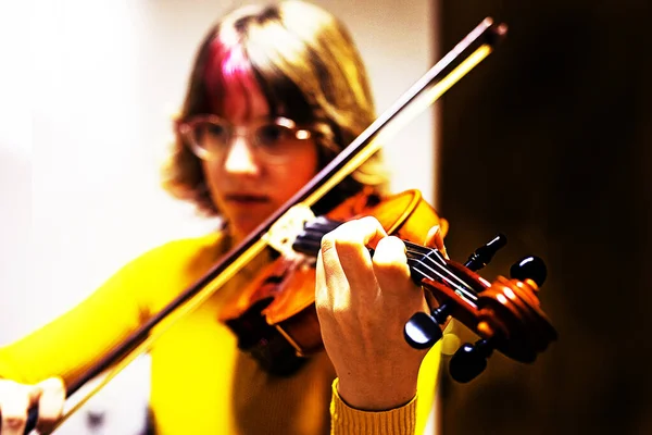attentively girl teenager violinist in glasses plays the violin with notes. Musical education