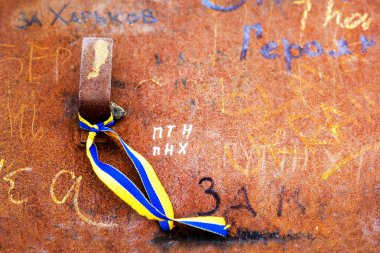 blue-yellow Ukrainian ribbon as a symbol tied to a piece of military equipment. War with Ukraine