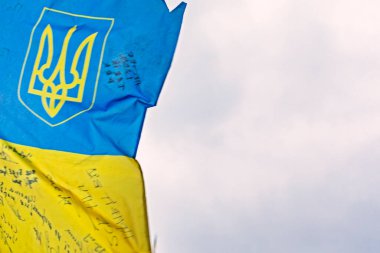 close-up of the flag of ukraine with a trident on the background of a cloudy sky. War in Ukraine