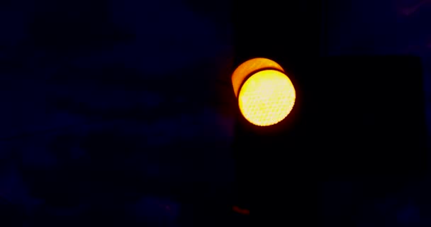 夕方に交通信号で街を横断する 夕方の空を背景に緑のオレンジと赤を交通標識で — ストック動画