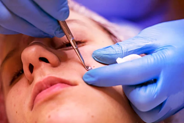 stock image beautiful girl teenager on the procedure at the beautician, squeezing out the pimples, horizontal