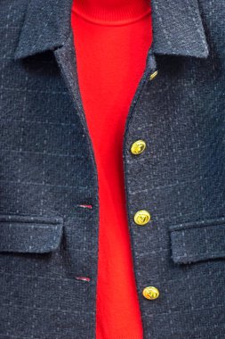 Koyu gri tüvit ceket, altın düğmeler ve kırmızı örgü süveter, dikey.