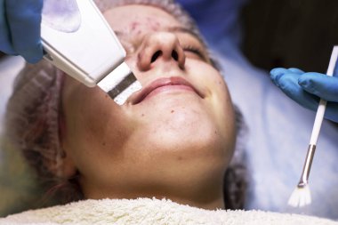 Mutlu kiracı kız lazer yüz temizleme için bir kozmetikçiyle randevuda.