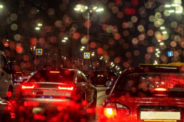 Akşam geç saatlerde, kötü hava durumu arabasının ön camında bir yağmur fırtınası sırasında yolda trafik sıkışıklığı. Yolculuk