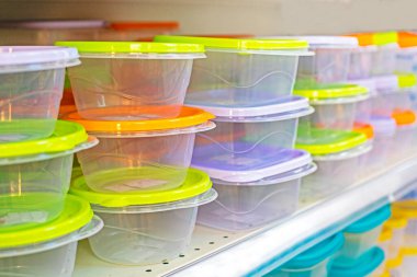 transparent plastic containers with colorful lids on the store counter, horizontal clipart