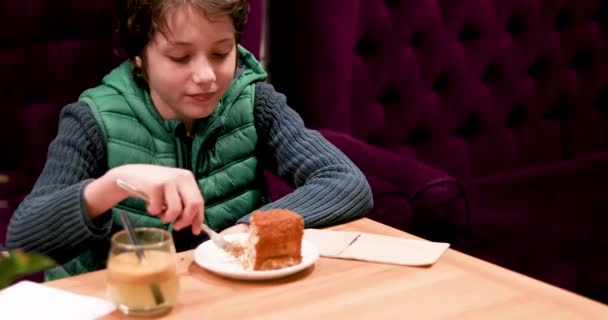 Rolig Pojke Grön Väst Äter Läcker Tårta Med Gaffel Mysig — Stockvideo